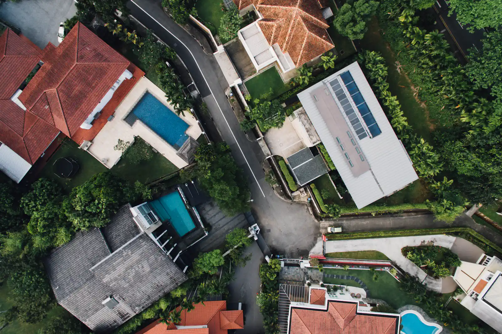 Vista aérea de un conjunto de viviendas terminadas con jardines y albercas